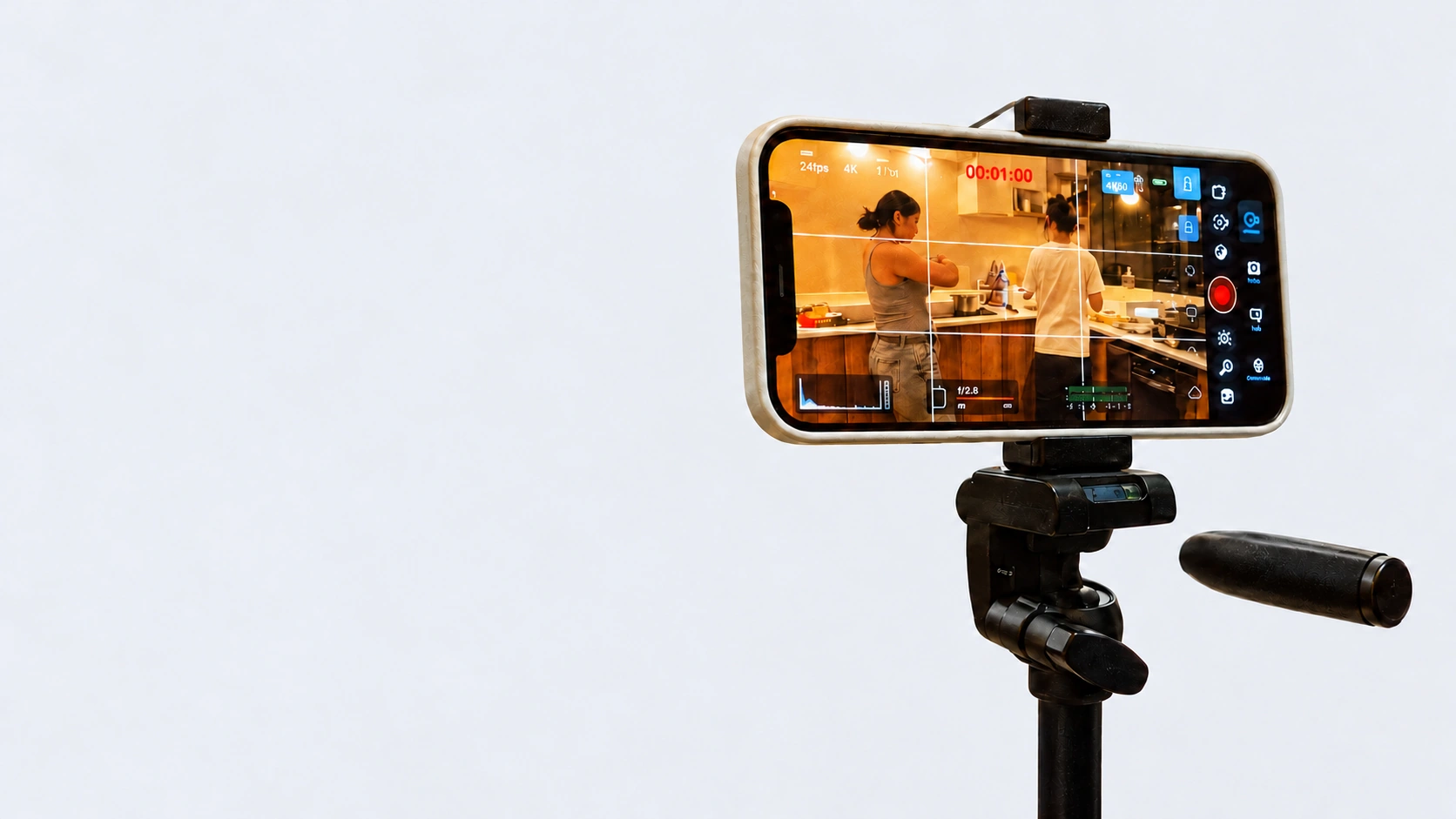 A phone recording a creator on a black tripod against a light grey background